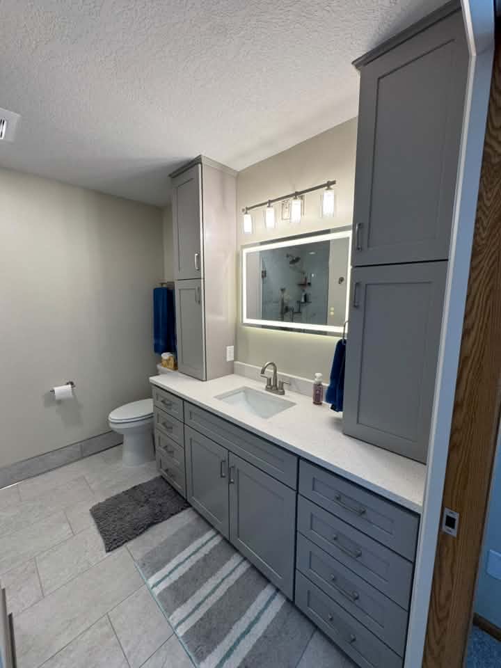 Tile installation in MN bath with grey cabinets 